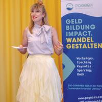 Raffaela Hofmann präsentiert vor einem PoGeBiX-Roll-up mit dem Slogan „Geld Bildung Impact. Wandel gestalten“