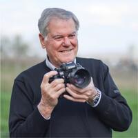 Fotograf Erich Janzso mit einer Spiegelreflexkamera im Freien